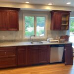 Painted cabinets, installed new white quartz countertops, and custom built an island to match.