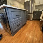 Painted cabinets, installed new white quartz countertops, and custom built an island to match.
